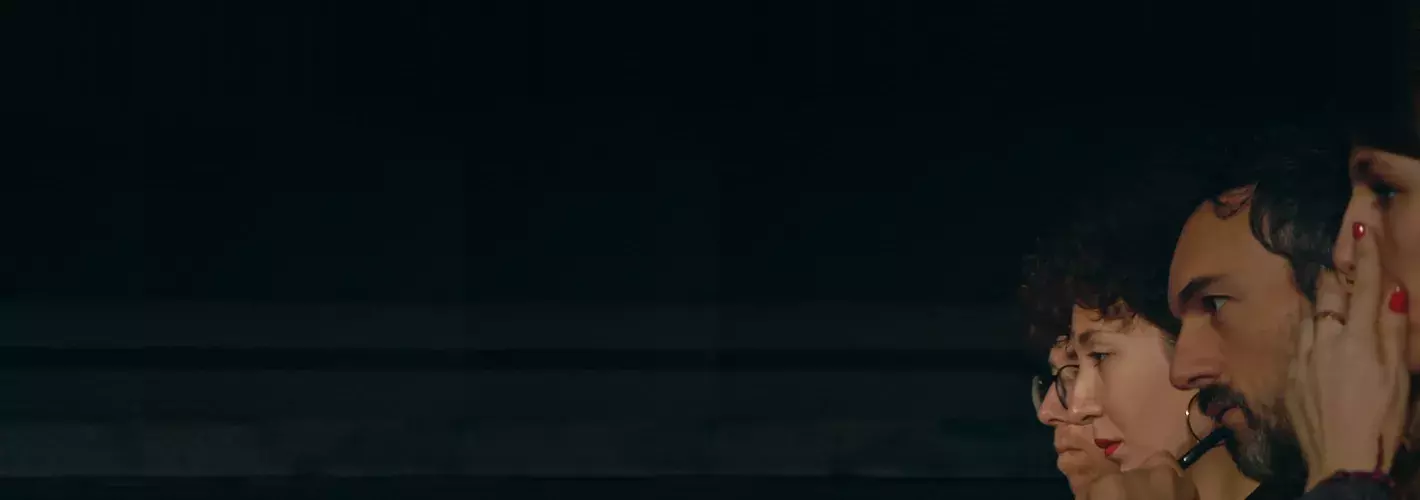 Rostros de perfil de cuatro personas que miran hacia un fondo negro