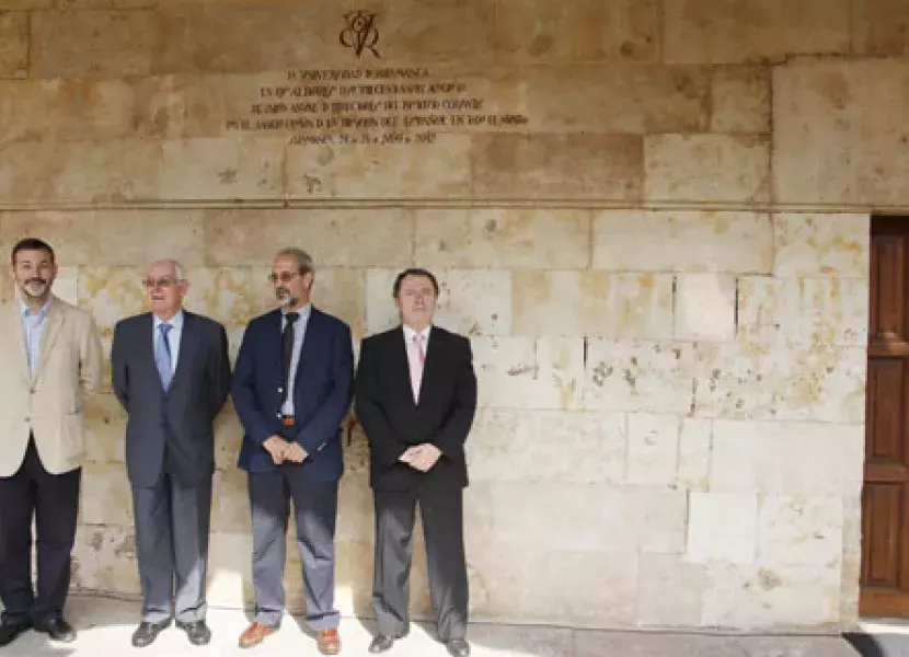 Foto de grupo posando ante el vítor descubierto en honor al Instituto Cervantes en el Patio de Escuelas Menores