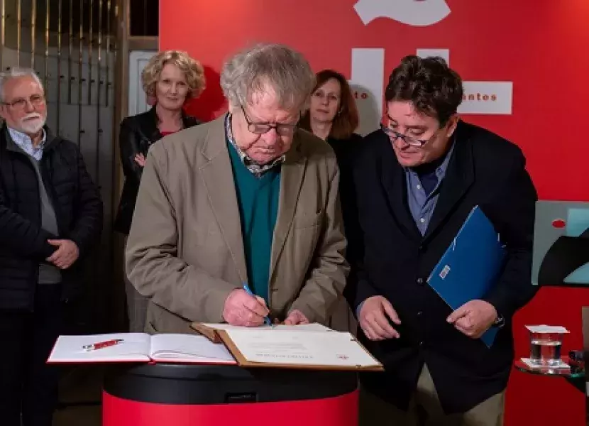 Ian Gibson firma en el libro de honor del Cervantes