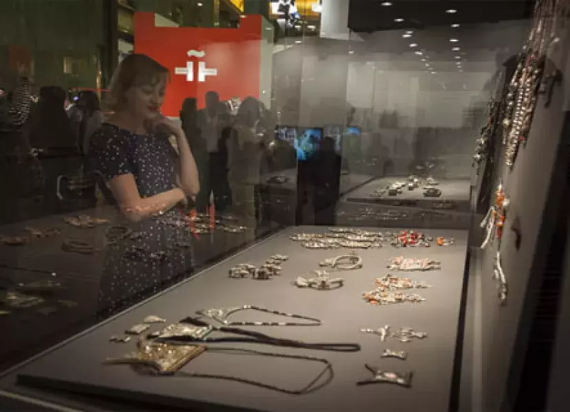 Una visitante a la exposición observando joyas