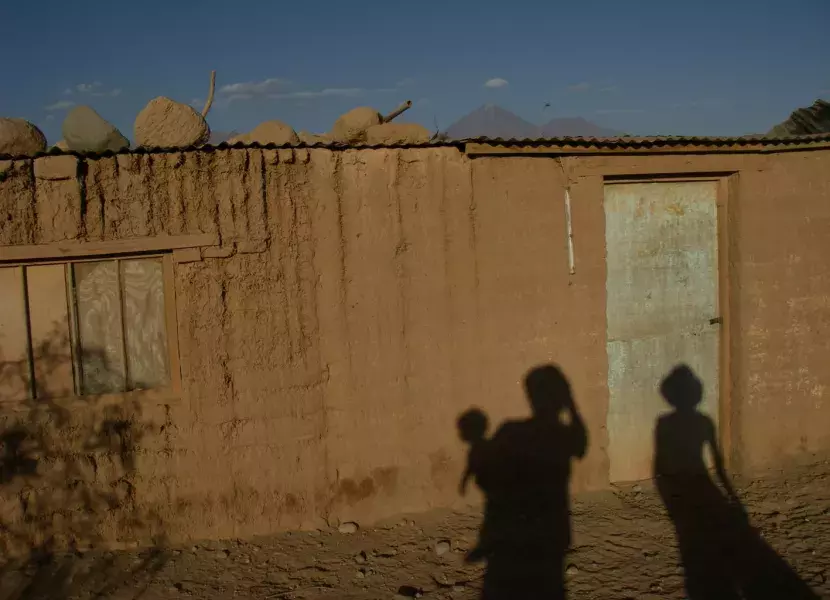 (Chile) La sombra de los tres proyectada en la pared de una simple casa de San Pedro de Atacama con el volcán Licancabur al fondo, 2007