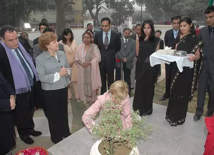María Teresa Fernández de la Vega planta una albahaca sagrada ante la atenta mirada de los asistentes