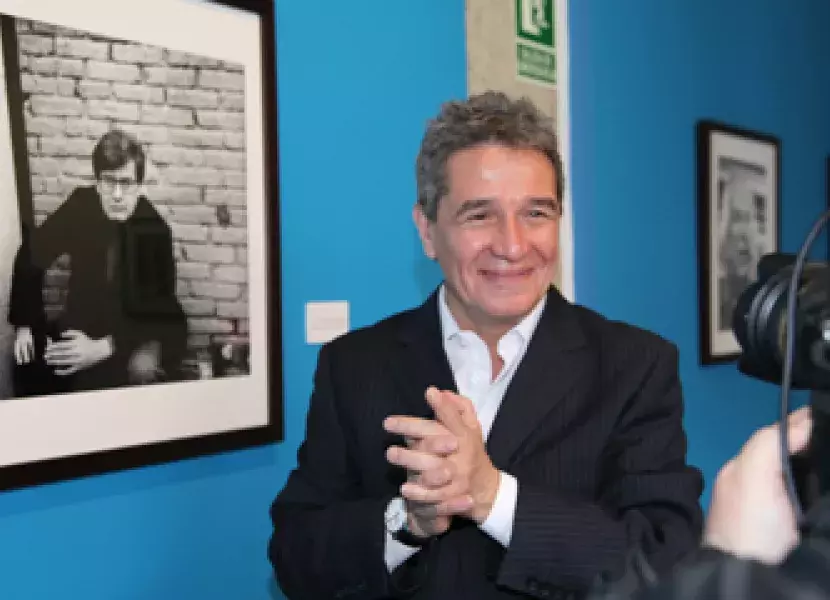 Rogelio Cuéllar es fotografiado frente al retrato de José Emilio Pacheco.