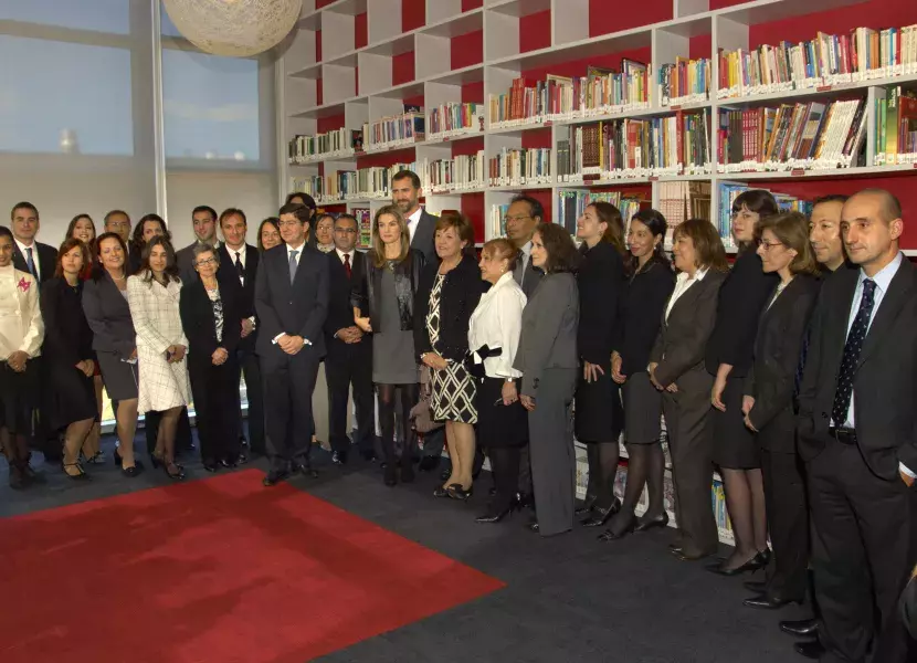 Los Príncipes y Carmen Caffarel posan en la biblioteca con el personal del centro.