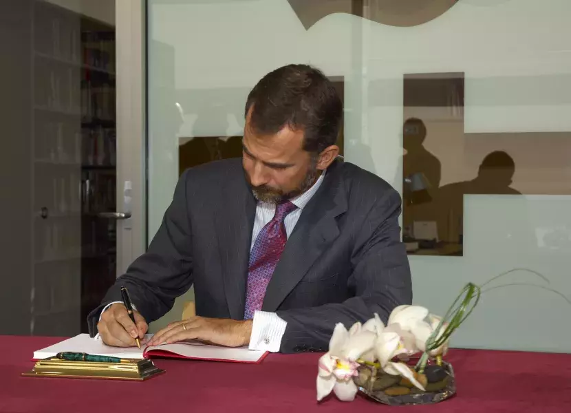 Don Felipe firma en el Libro de Honor del centro.