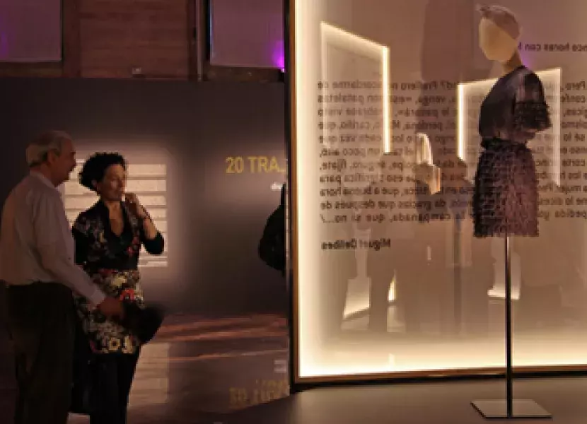 El escritor y la comisaria de la exposición observan el traje de la diseñadora Carmen March.