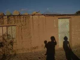 (Chile) La sombra de los tres proyectada en la pared de una simple casa de San Pedro de Atacama con el volcán Licancabur al fondo, 2007