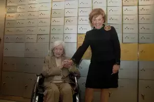 Ana María Matute y Carmen Caffarel ante la pared de cajas de seguridad de la Caja de las Letras donde se encuentra la nº 1.526