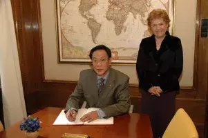 El ministro de Educación filipino, Jesli A. Lapus, firma en el Libro de Honor del Instituto Cervantes. A su lado, Carmen Caffarel