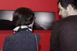 Algunos de los visitantes a la inauguración «Peso y levedad» comentan las fotografías expuestas.