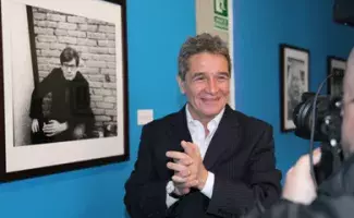 Rogelio Cuéllar es fotografiado frente al retrato de José Emilio Pacheco.