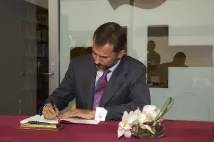 Don Felipe firma en el Libro de Honor del centro.