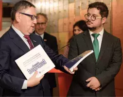 El embajador de Chile, Javier Velasco (dcha.) escucha las explicaciones del rector Nelson Vásquez sobre los libros donados al Instituto Cervantes