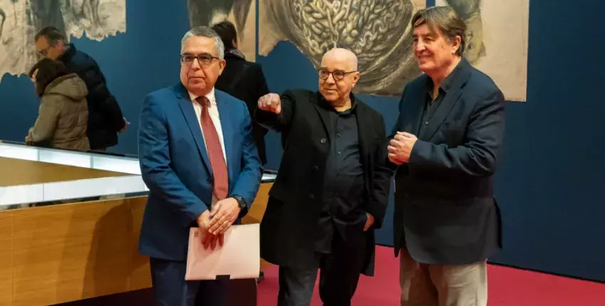 El artista Roberto Fabelo muestra una obra de su exposición al director del Instituto Cervantes, Luis García Montero (dcha.) y al embajador de Cuba en España, Marcelino Medina (izda.).