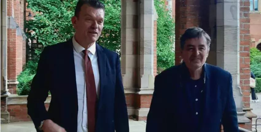 El virrector de Queen's University, Richard Miles, (izda.) y el director del Instituto Cervantes, Luis García Montero, pasean por el campus de la universidad en Belfast.