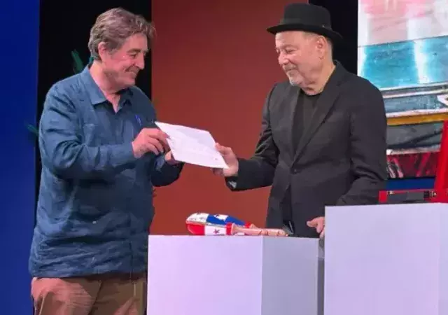  El director del Instituto Cervantes, Luis García Montero, recibe de Rubén Blades un folio con la letra de su mítica composición «Patria», lanzada en 1988 en su álbum «Antecedentes», un himno que redefine el concepto de nación. El tema fue compuesto por Blades mientras residía fuera de su Panamá natal.