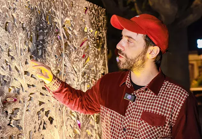 El artista Julián Pesce junto a su instalación