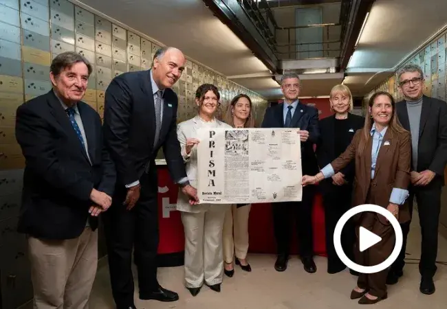 Foto de familia de los participantes en el legado sosteniendo un ejemplar de la revista mural literaria Prisma, en la que participó Borges.
